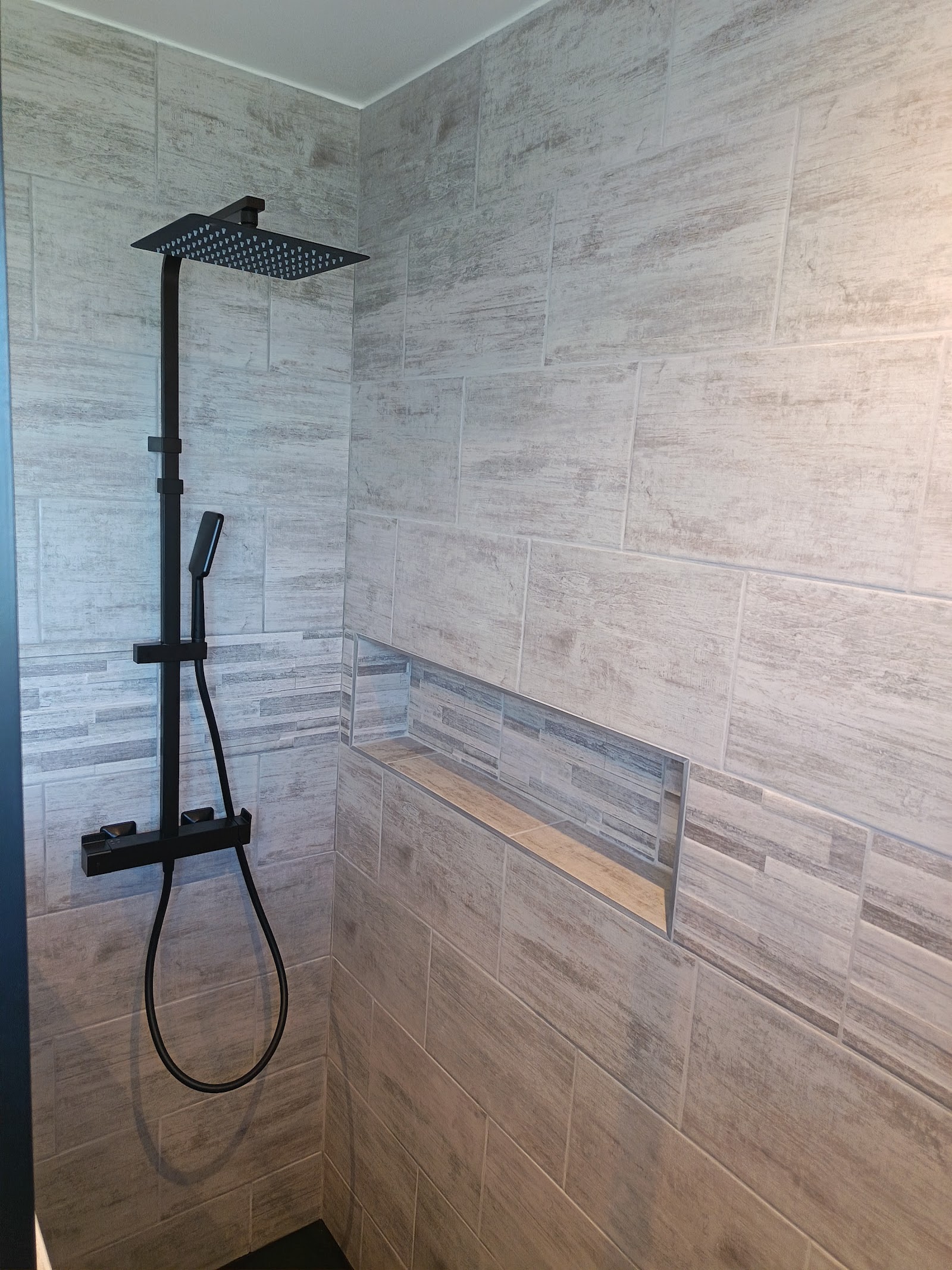 Douche à l'italienne avec faïence effet bois gris et robinetterie noire mate