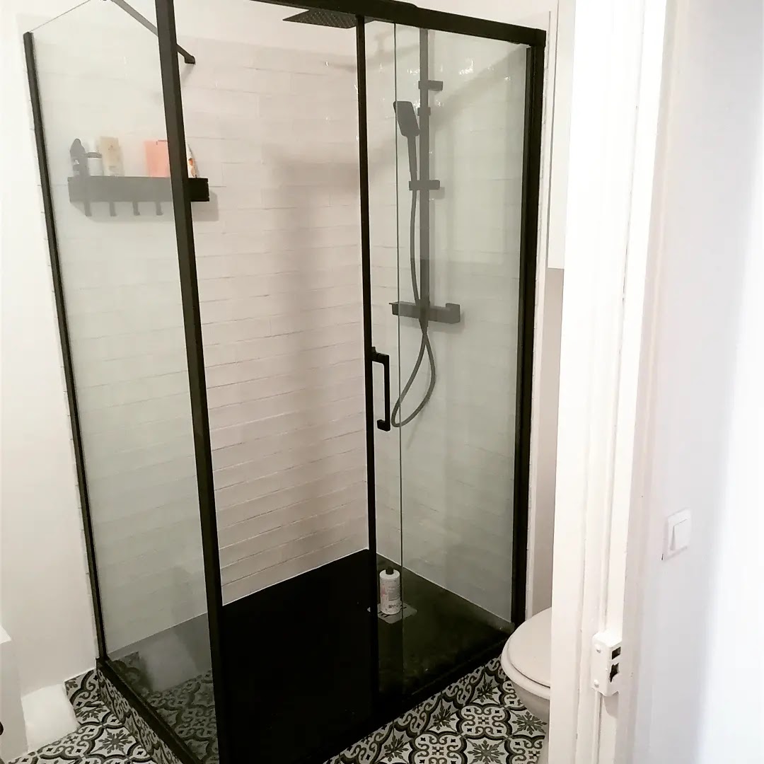 Douche vitrée avec faïence blanche et sol à motifs graphiques